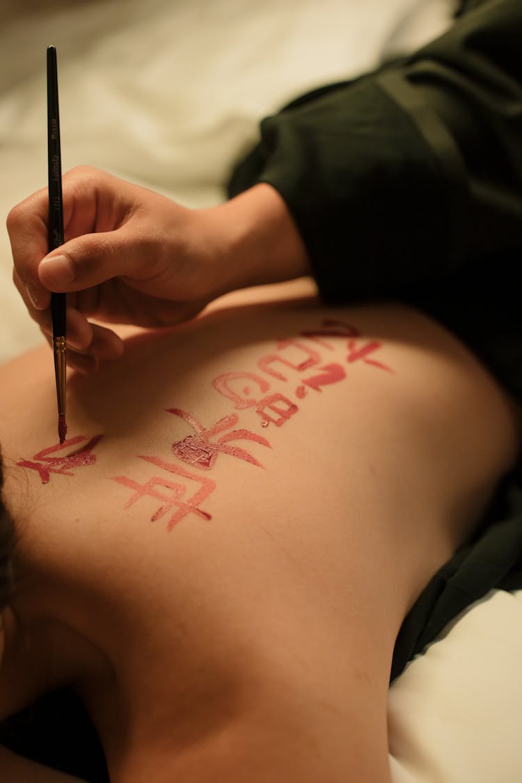 Person Writing On Woman's Back