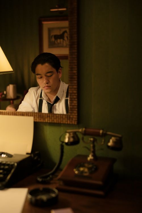 Free A man reflected in a mirror at a vintage desk with a typewriter and lamp. Stock Photo