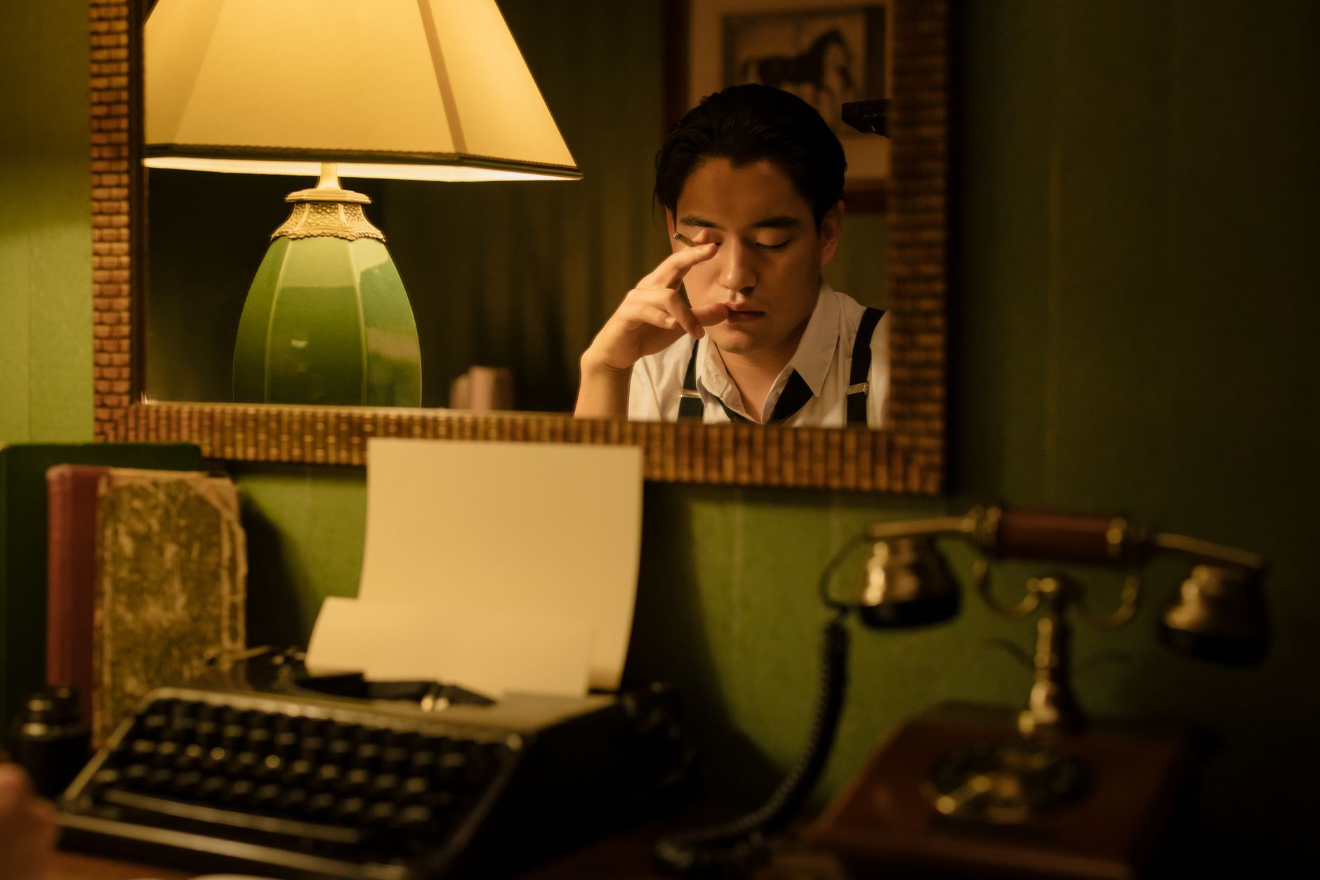 A vintage-themed scene with an Asian man in reflection, featuring a typewriter and lamp.