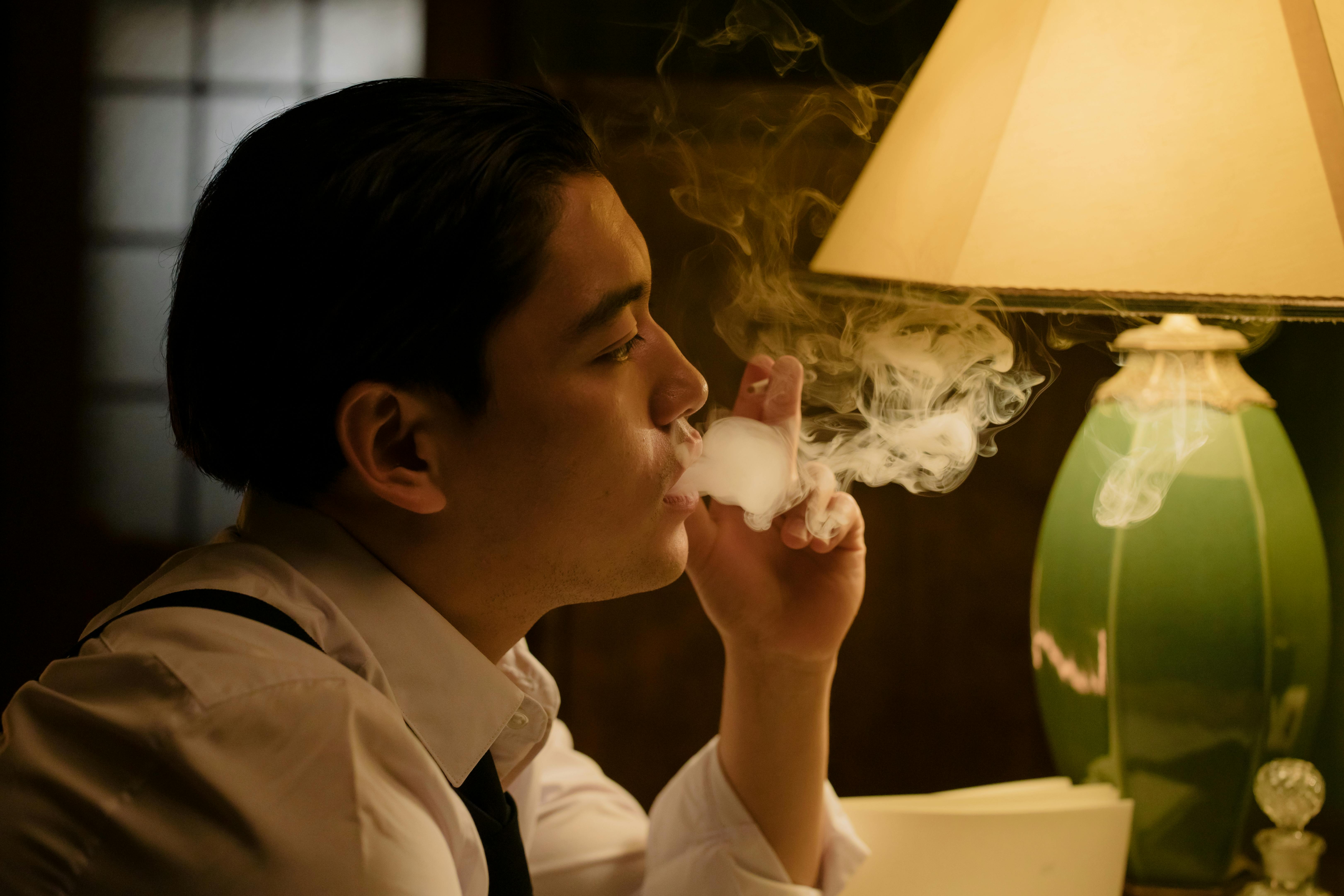 man in white dress shirt smoking