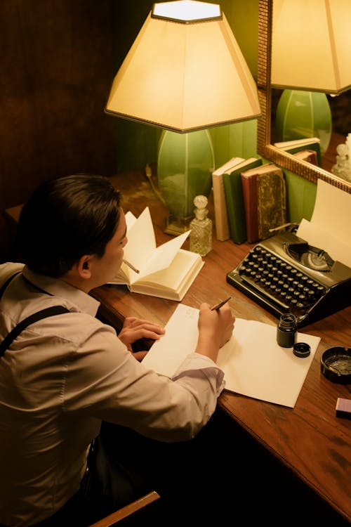 Free Man Writing on a White Paper Stock Photo