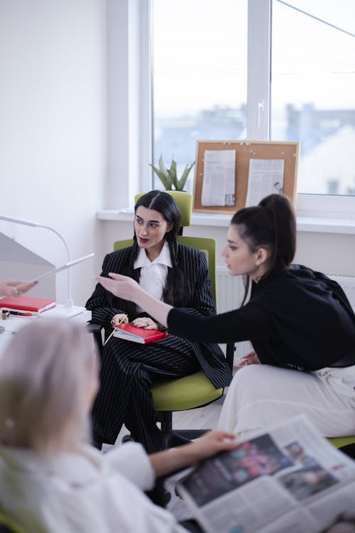Free Women Sitting on a Chair while Having Conversation Stock Photo