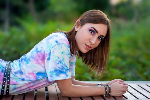 A Woman in Printed Shirt Lying on a Bench