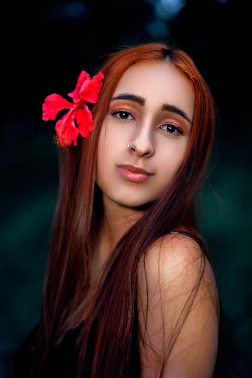 A Beautiful Woman with Red Flower on Her Hair