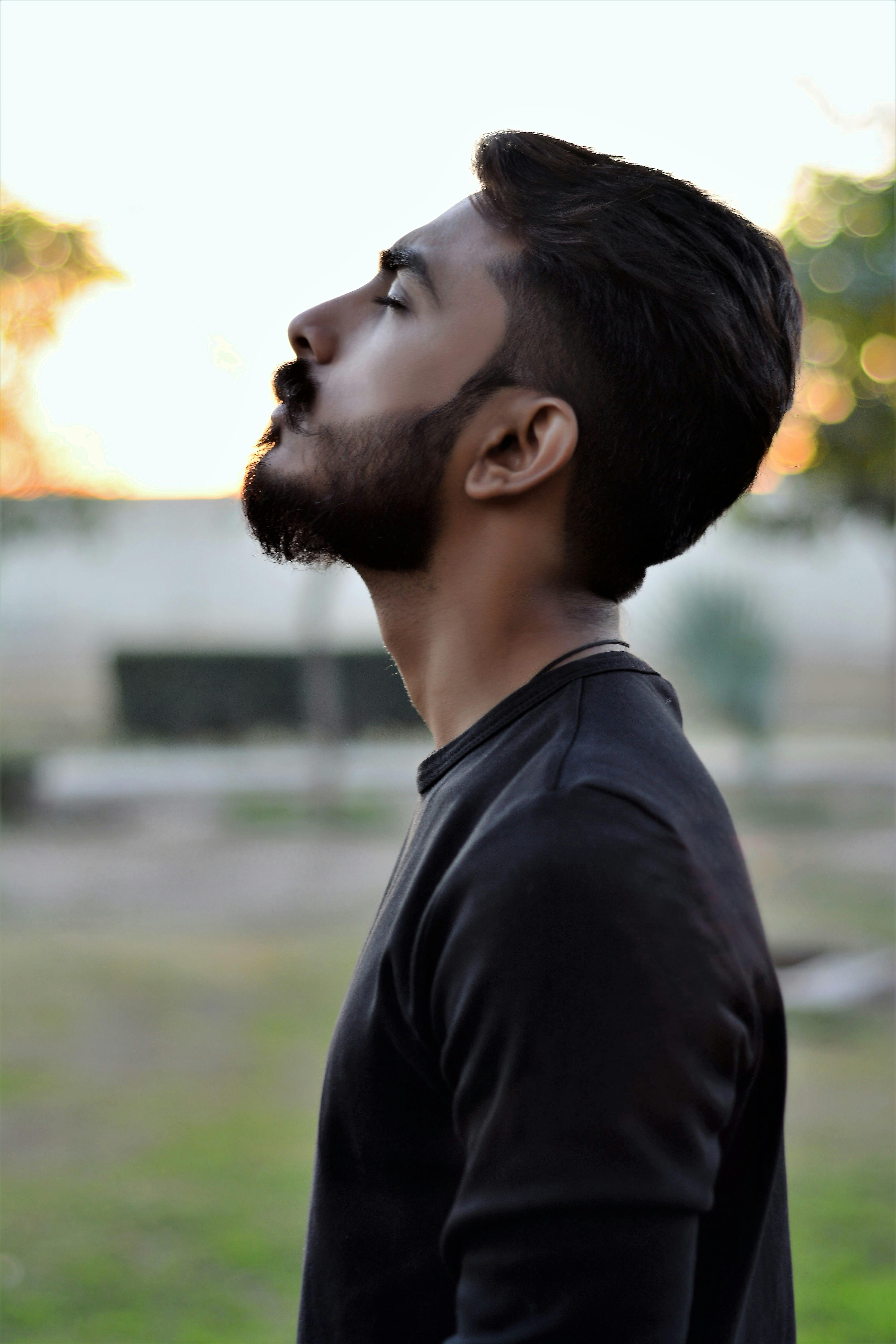 Young indian man wearing blue polo standing over isolated yellow background  looking to side, relax profile pose with natural face with confident smile.  Stock Photo | Adobe Stock