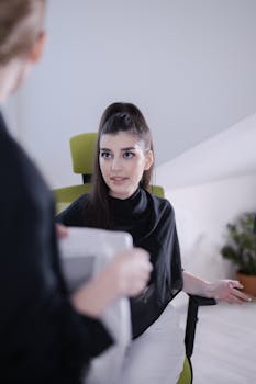 Young professional woman engaged in a focused discussion in a modern office setting.