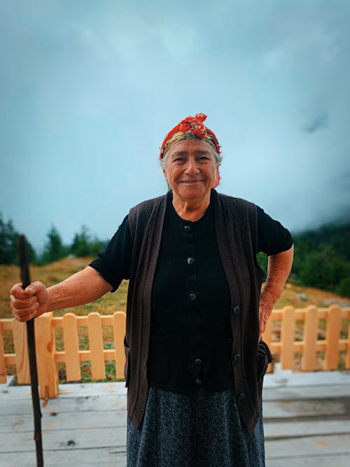 Elderly Woman Smiling While Holding a Stick