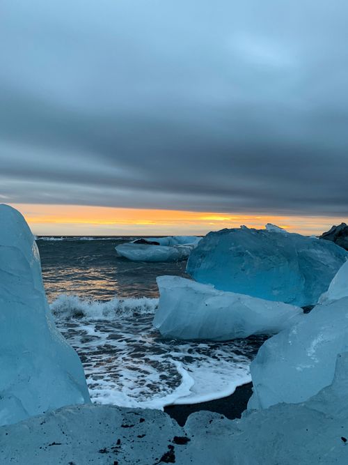 Free Captivating scene of icebergs on an Icelandic shore against a vivid sunset sky. Stock Photo