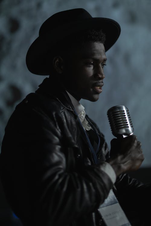 A Man in Black Leather Jacket Holding a Microphone