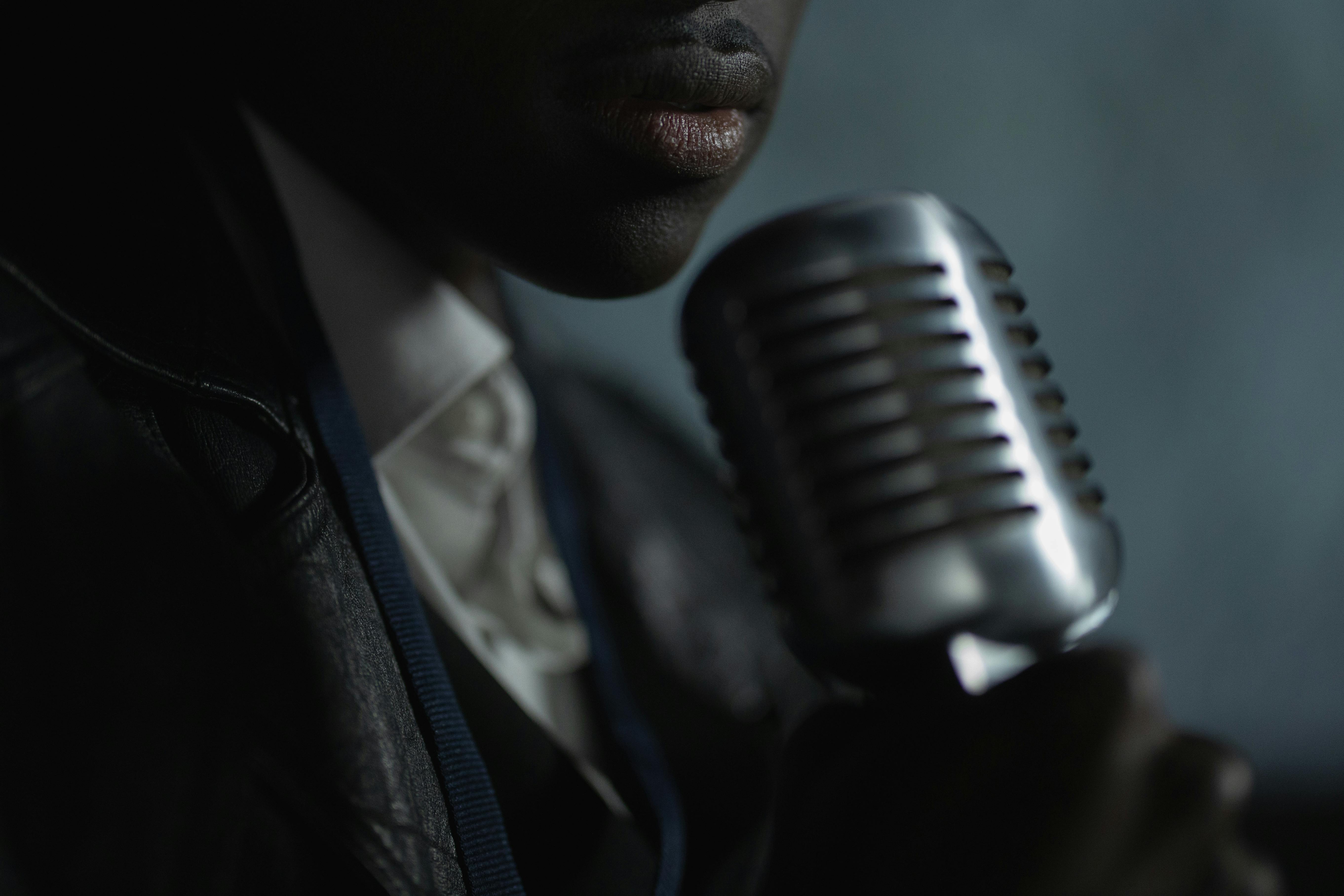 Close-up of a singer holding a vintage microphone, dim lighting creating an intimate mood.