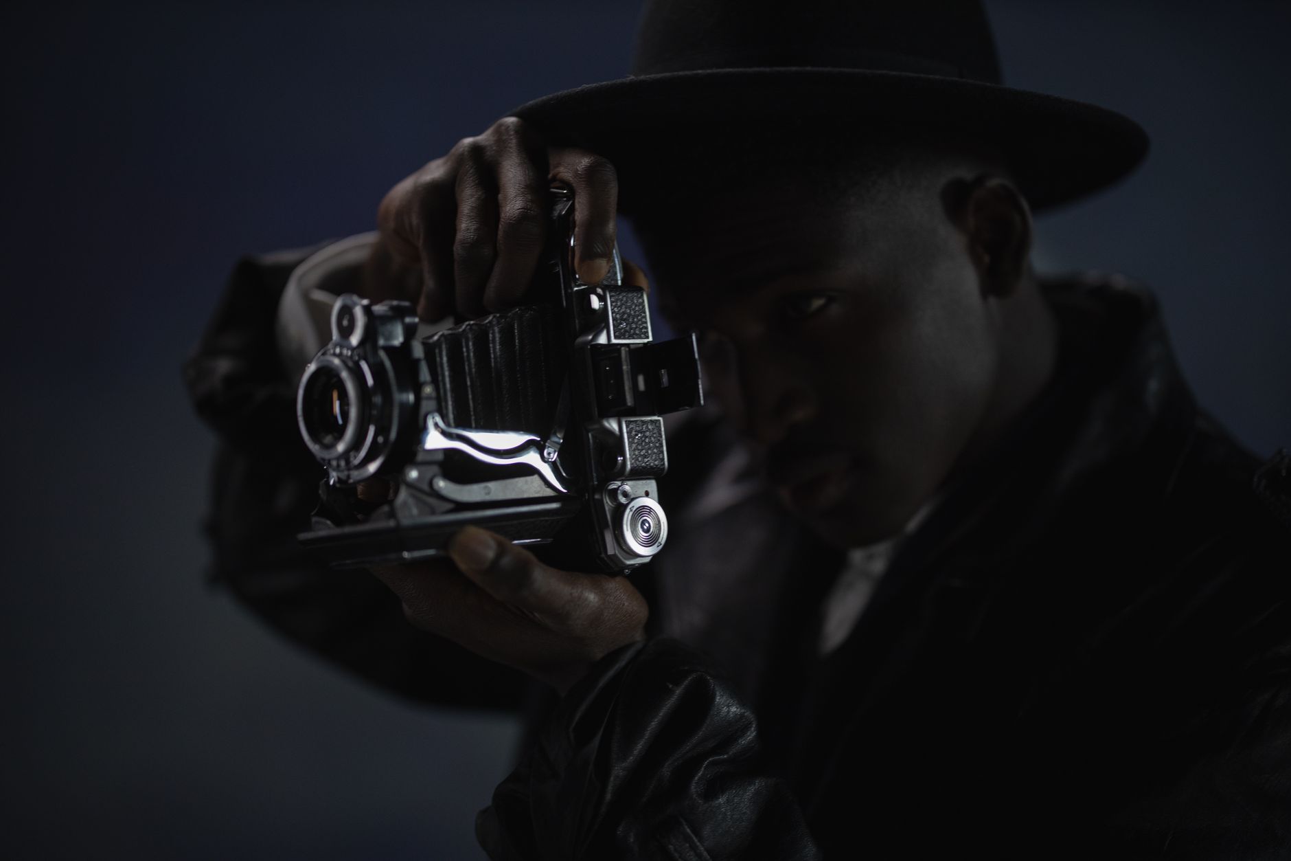 Man in Hat Using Old Camera