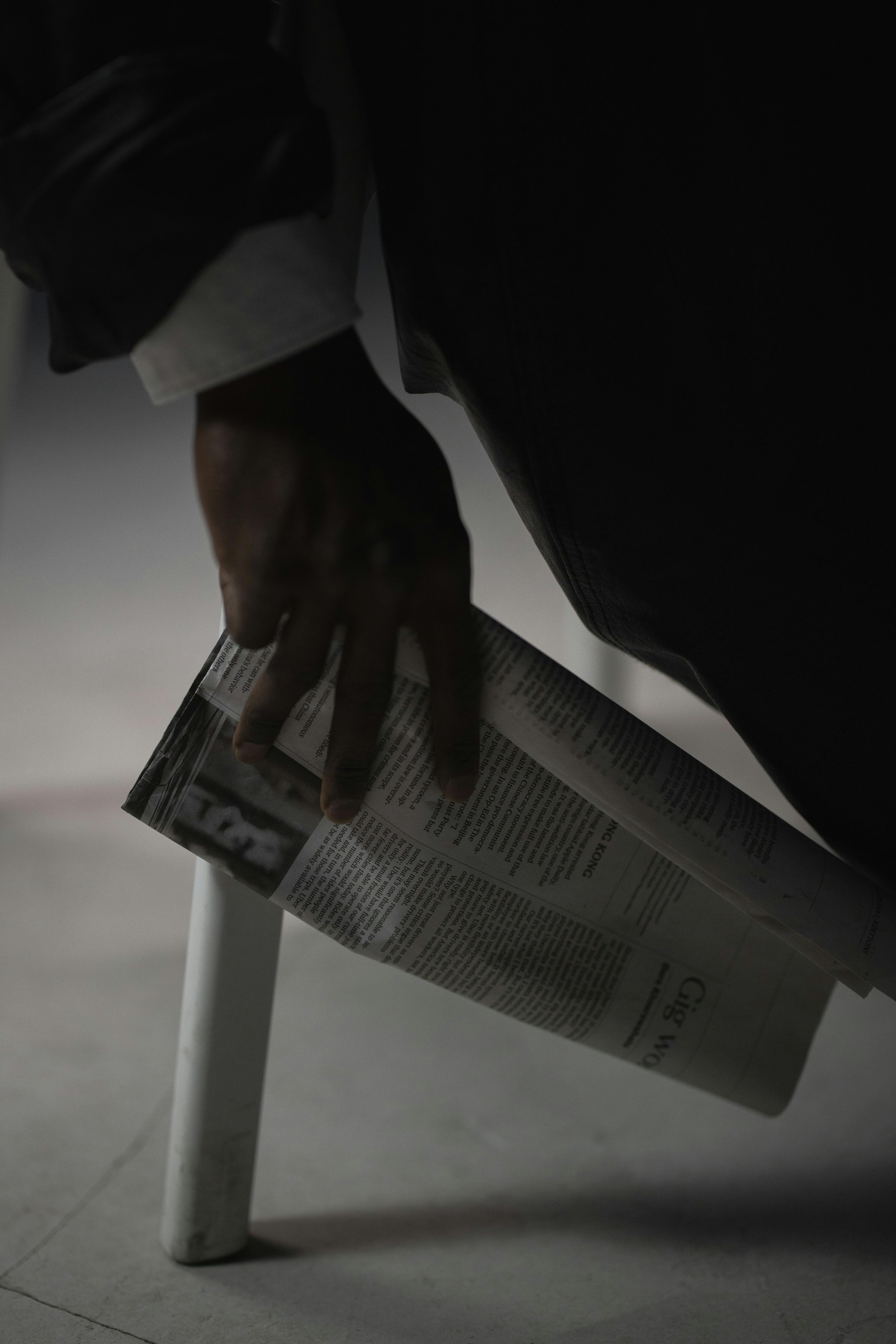 human hand holding a newspaper