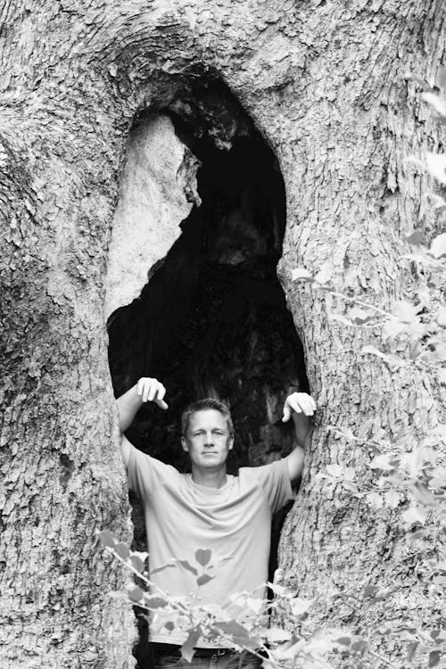 Greyscale Photography of Man Inside the Cave