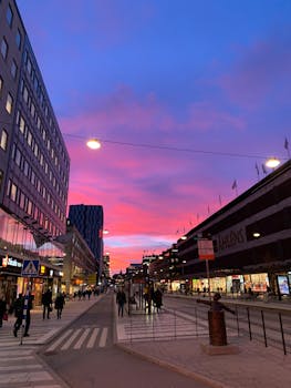 Vibrant sunset over a bustling street in Stockholm, showcasing urban life with colorful skies.