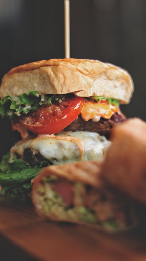 Appetizing hamburger with delicious fresh vegetable and meat cutlet served on table in fast food cafe