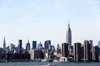 在晴朗的蓝天下，俯瞰纽约市天际线的壮丽景色，帝国大厦格外引人注目