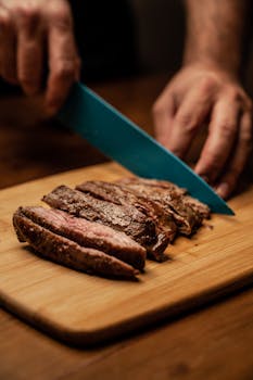 A chef skillfully slices perfectly cooked steak on a wooden board, showcasing culinary precision.