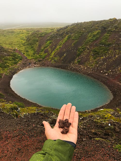 A Person Holding Soil in Front of Kerid Crater