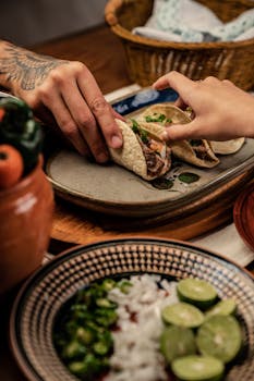 Two people enjoying delicious Mexican street tacos served with fresh ingredients on a rustic table.