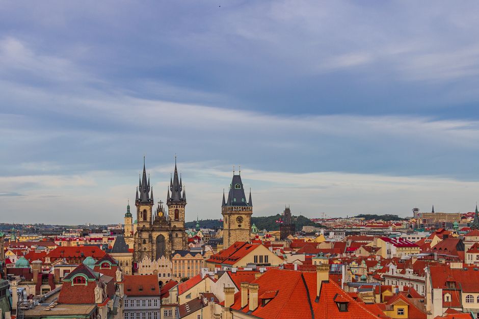 Hand holding a Czech prepaid SIM card with a blurred Prague background