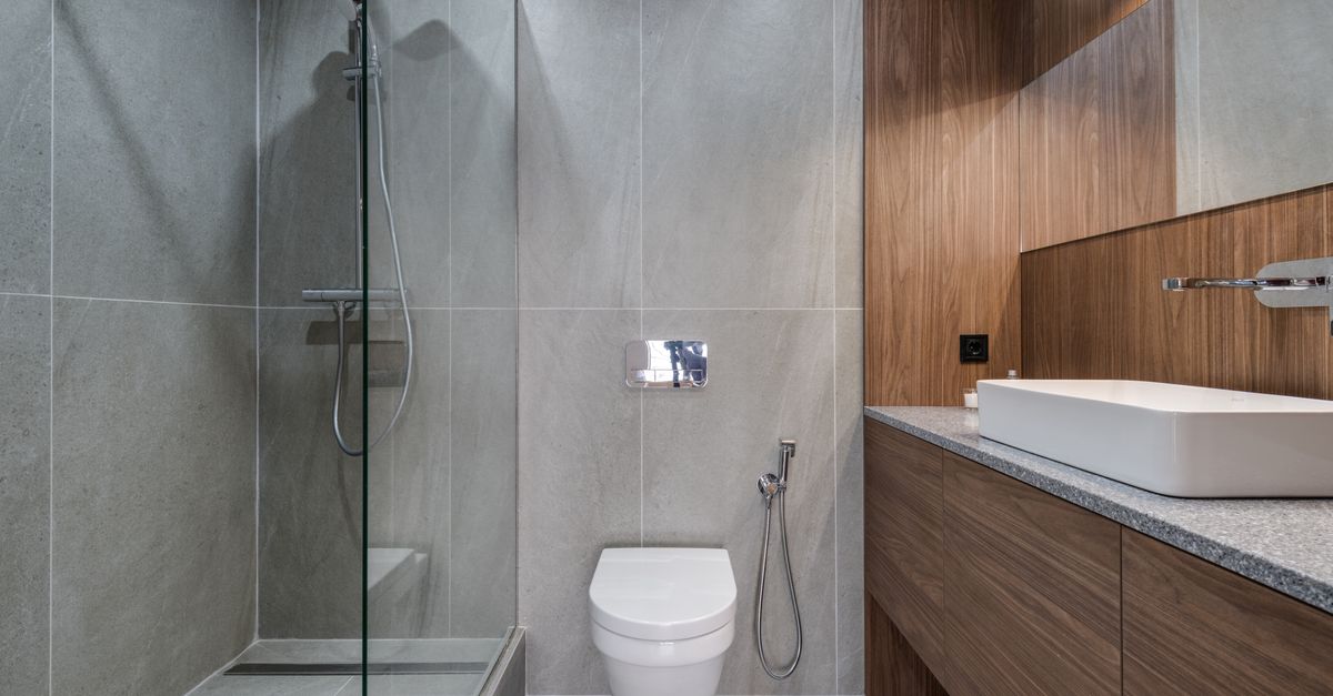 A clean, bright walk-in shower with a warm wood finish.