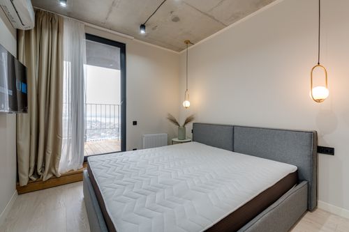 Free Minimalist bedroom featuring modern furnishings and stylish lighting, ideal for contemporary living. Stock Photo