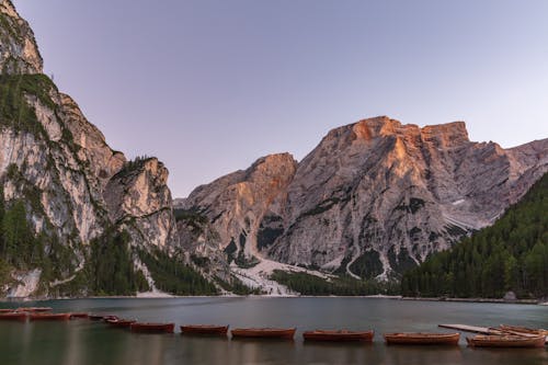 Boats floating on lake among rocky mountains