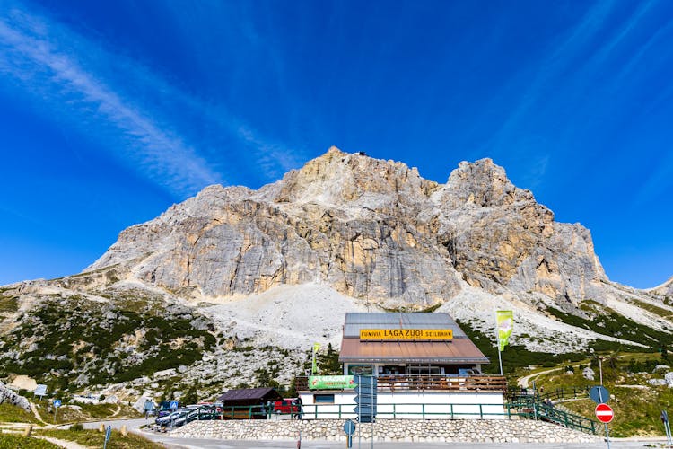 Houses Placed Near Dolomite Mountains Under Cloudless Blue Sky