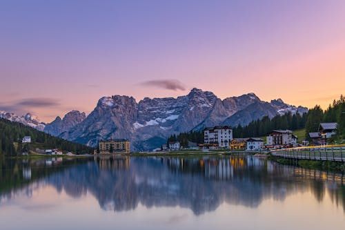 Free Small village located near lake and mountains at sunset Stock Photo
