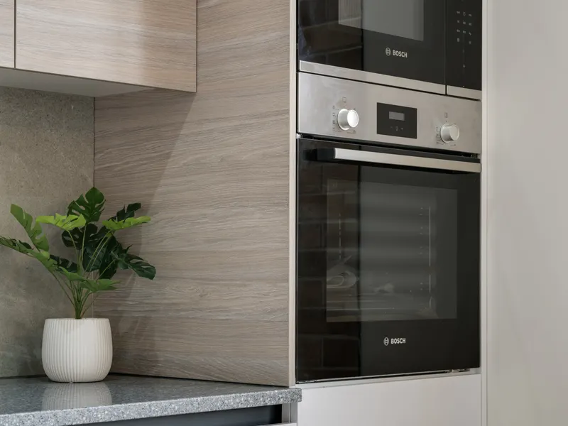 Refrigerator care guides Sleek modern kitchen with built-in appliances and a plant on the counter