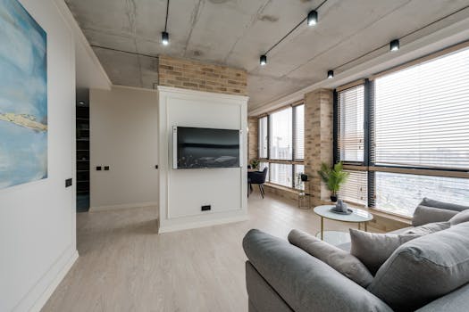 Spacious modern living room with urban view and mounted TV.