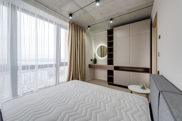 Bright bedroom with pale linen and a full-height window
