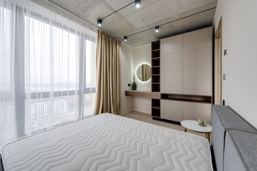 Free Bright minimalist bedroom with a large window and modern furniture design. Stock Photo