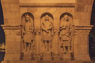 Carved sculptures of warriors on stone arched passage of monument Fishermans Bastion in Budapest at night