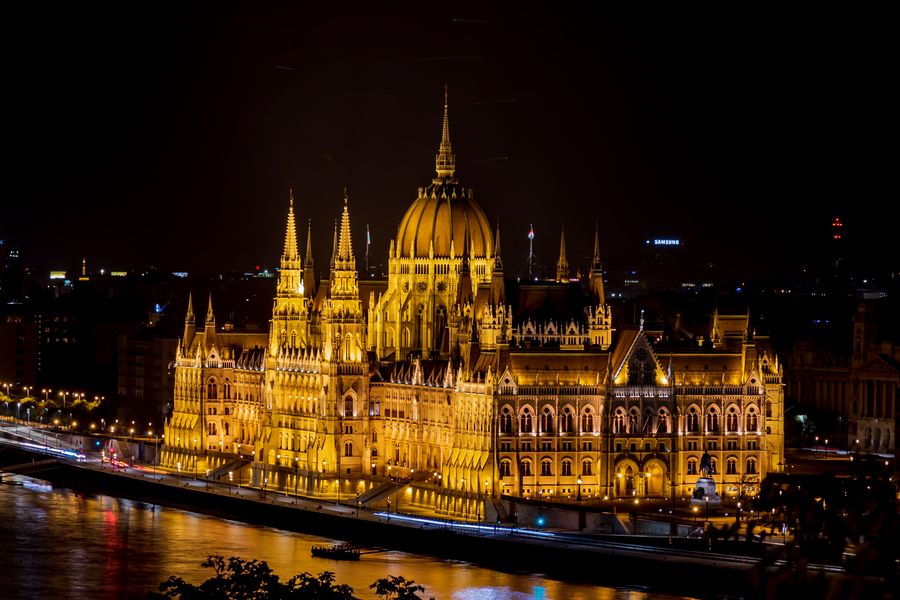 Illuminated Hungarian Parliament reflected in the Danube at night, the skyline behind a free Budapest dating site