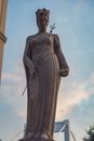 From below of aged stone sculpture of saint duchess in crown with mace and scepter in Budapest