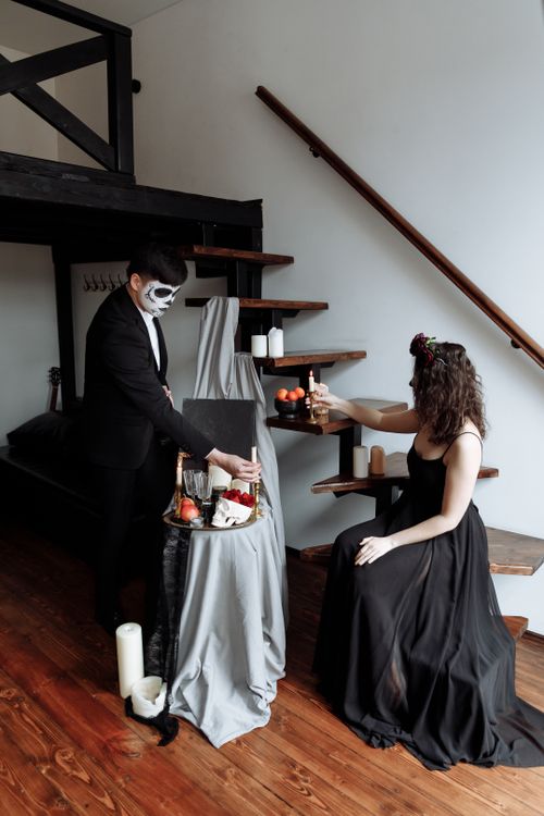 Free Elegant Dia de los Muertos celebration with a couple indoors, in traditional costumes. Stock Photo
