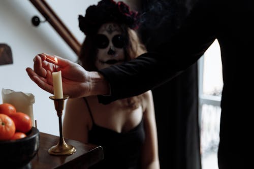 A Person Lighting a Candle Using a Matchstick