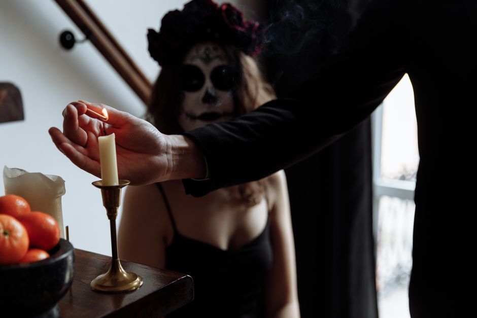 Como Criar um Ritual de Desapego Emocional e Autocuidado 2 An artistic depiction of a Dia de los Muertos ritual with intricate face paint and candle lighting.