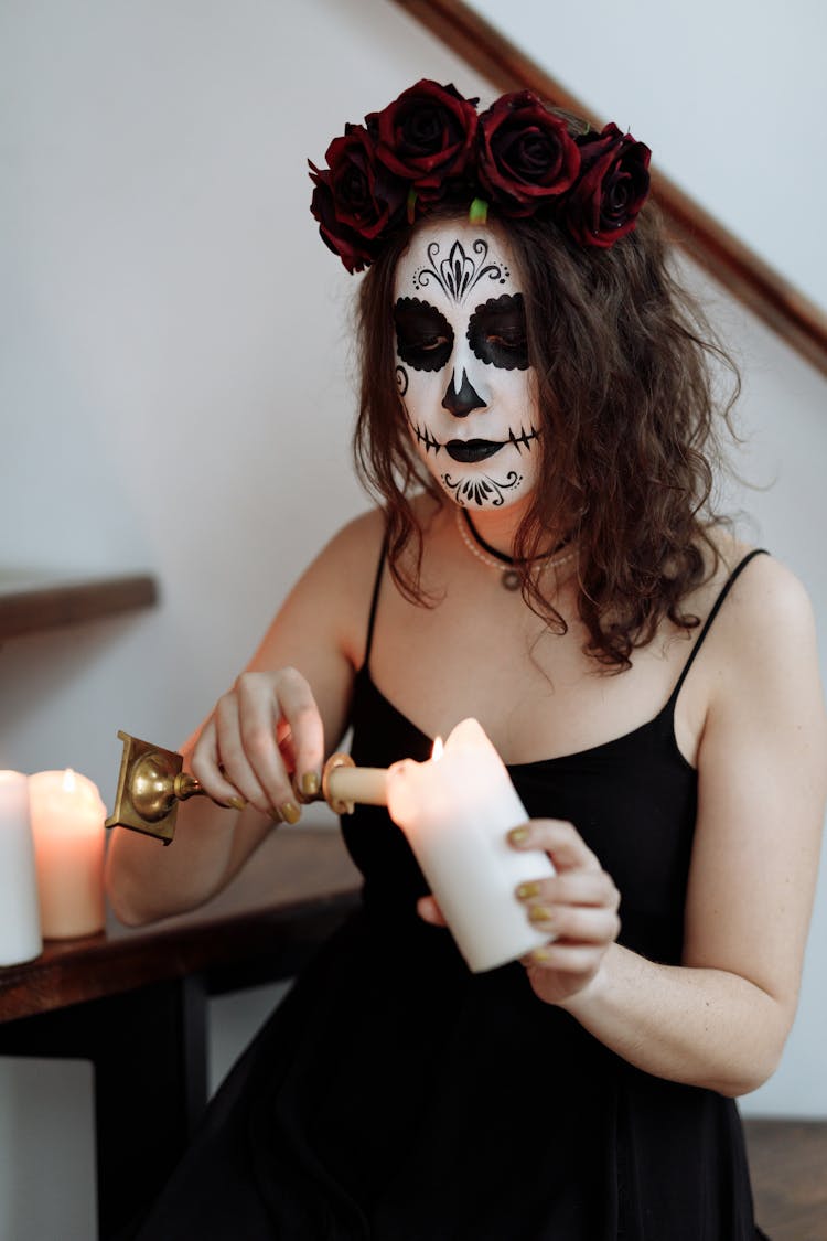 A Woman In Black Dress Holding A Candle