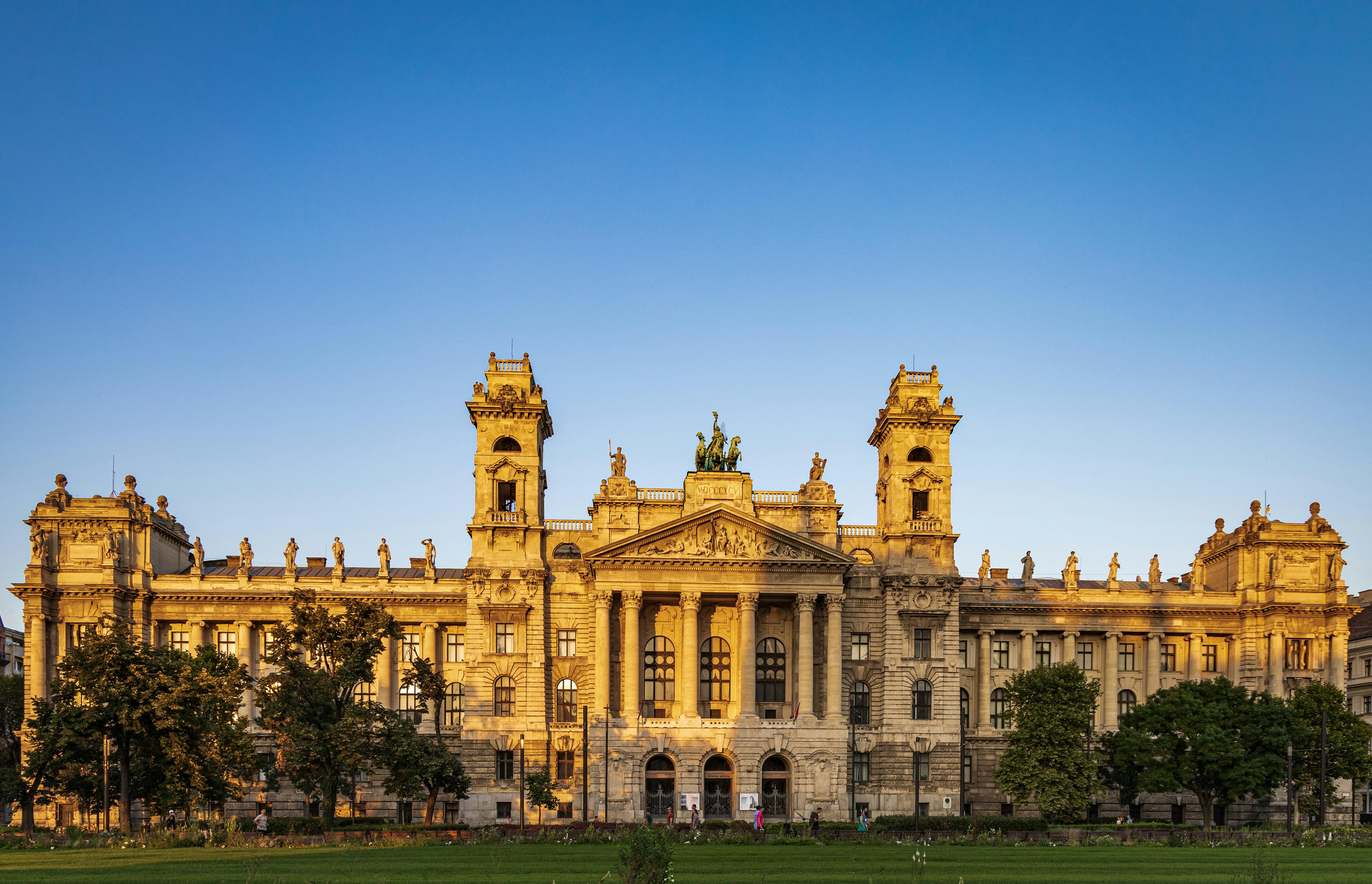 Historic building facade of the Hungarian National Museum in Budapest during golden sunset.