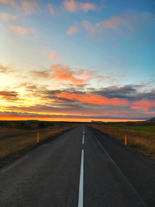 Free A serene countryside road in Sweden captured during a vibrant sunset. Stock Photo