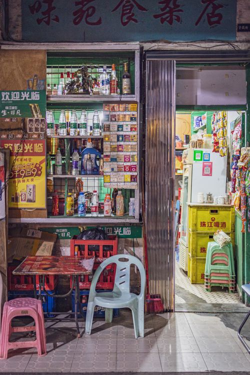 Free Colorful storefront in Guangzhou with chairs and stocked shelves under warm lighting. Stock Photo