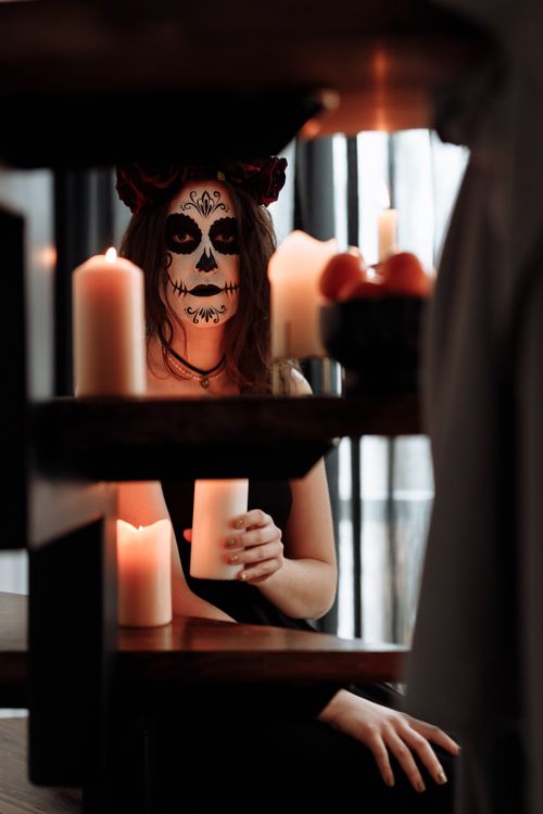 Free Woman in calavera makeup celebrating Dia de los Muertos with candles. Stock Photo