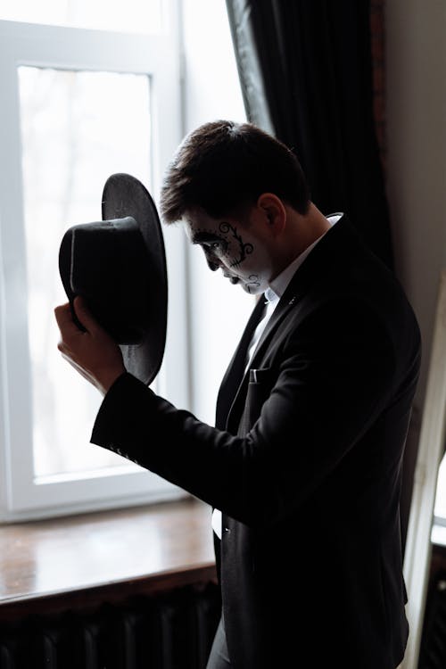 A Man in Black Suit with Creepy Face Paint