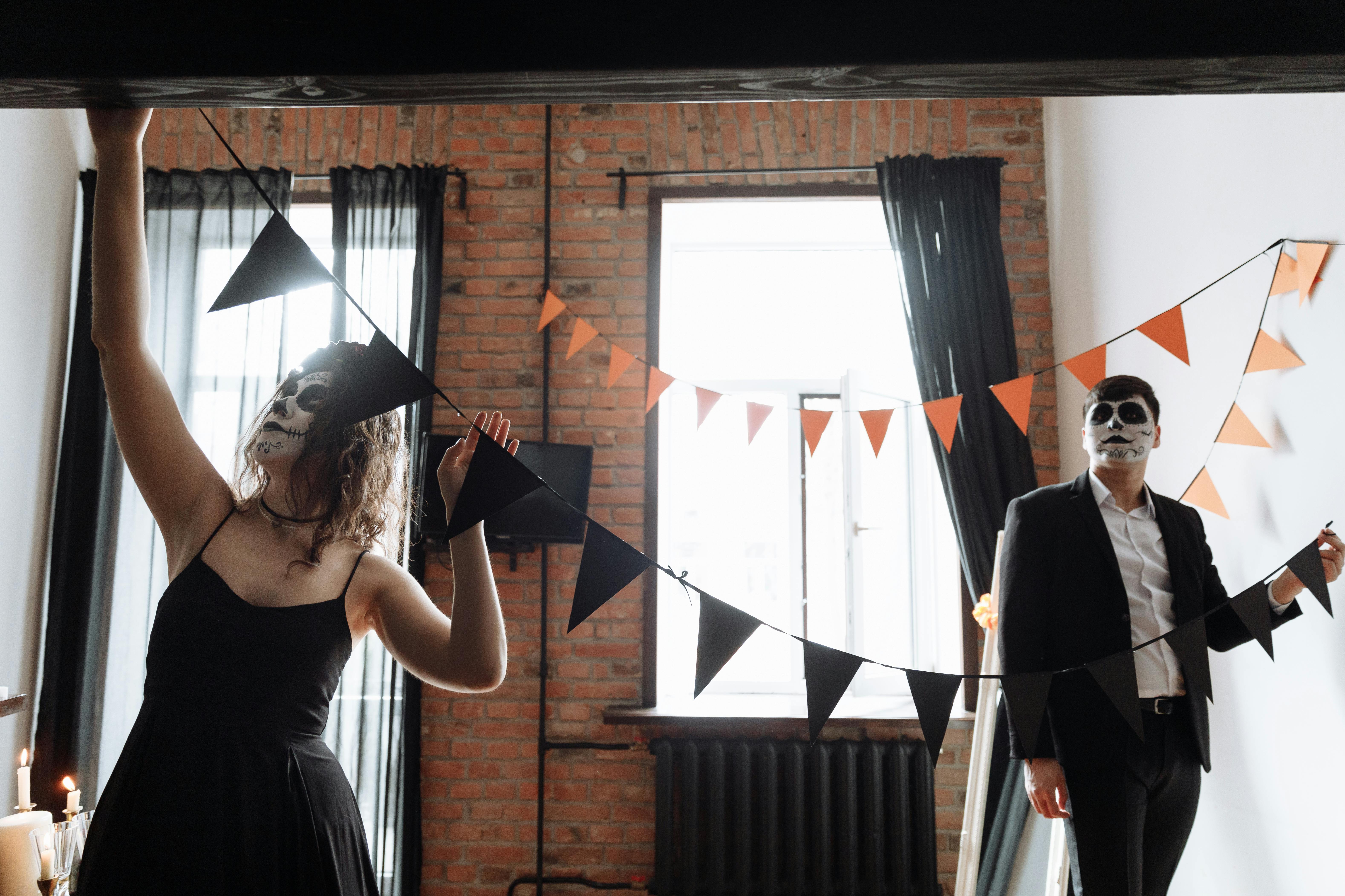 Free Two adults with face paint decorate for Day of the Dead indoors. Stock Photo