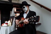 Man in Black Hat Playing Guitar