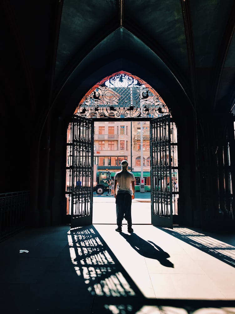 Back View Of A Man Standing Under A Pointed Arch