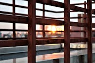 透过纽约屋顶的现代金属栏杆，可以宁静地欣赏日落景色