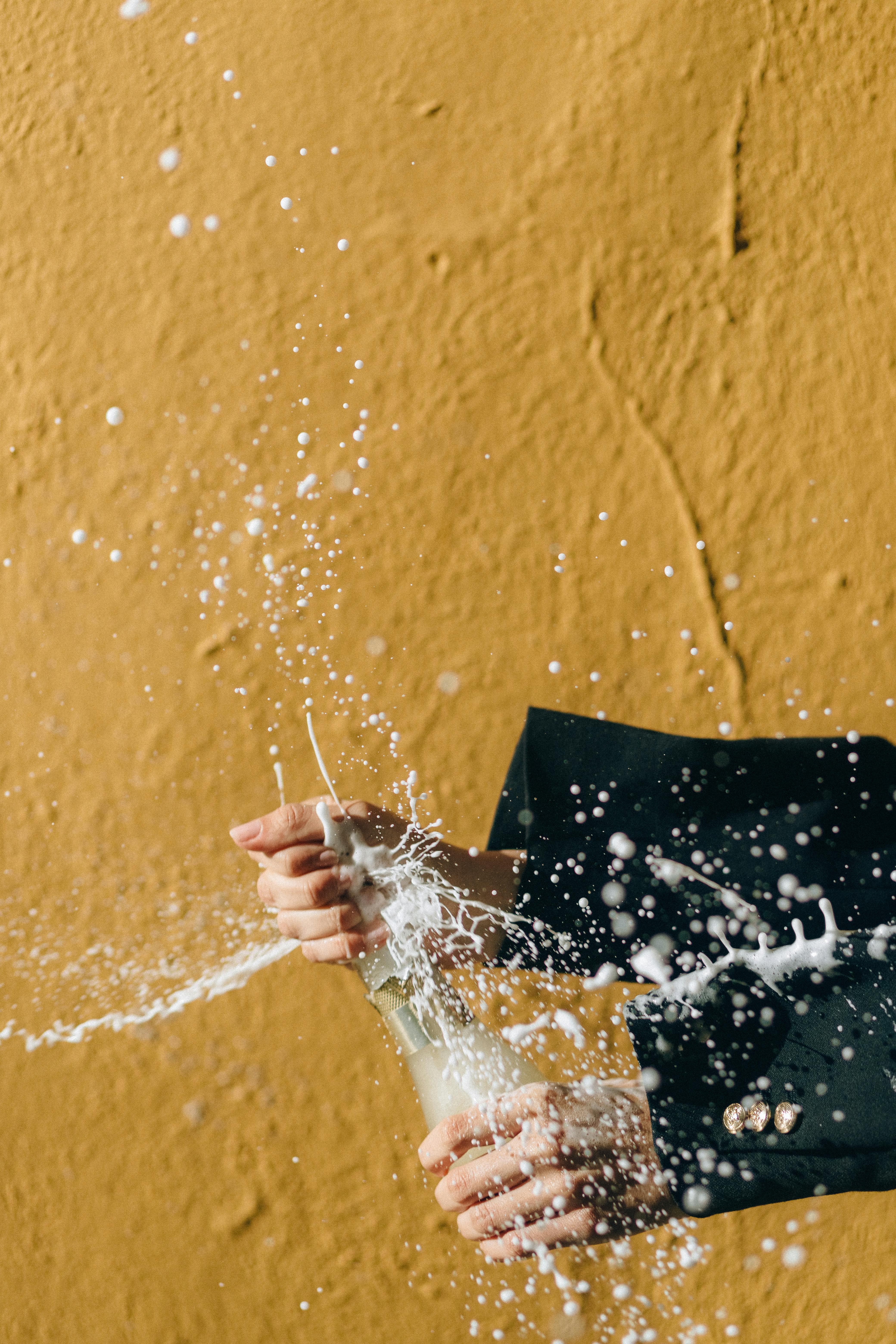 a person s hands popping a champagne bottle